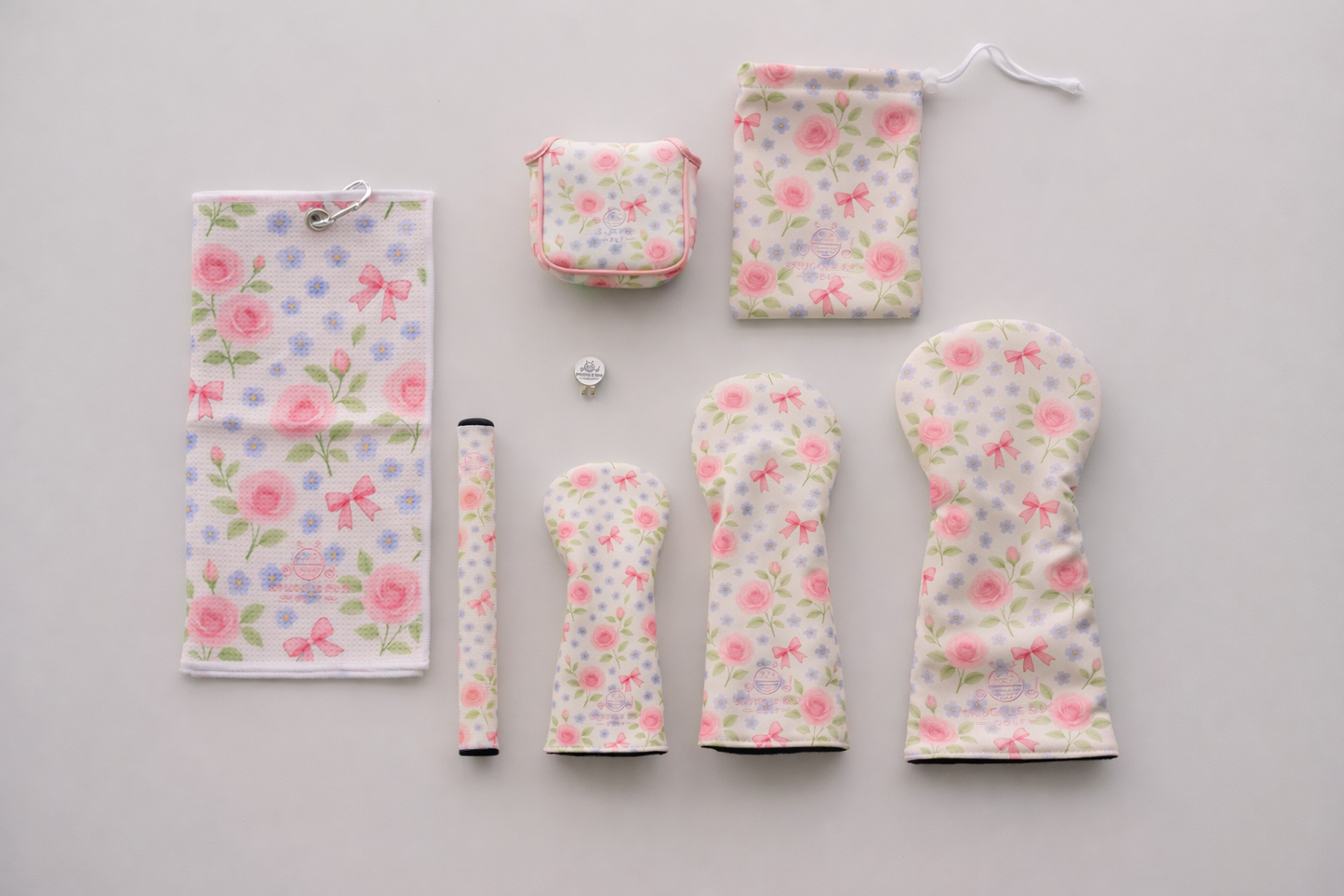 Set of floral-patterned golf club covers and accessories on a gray background