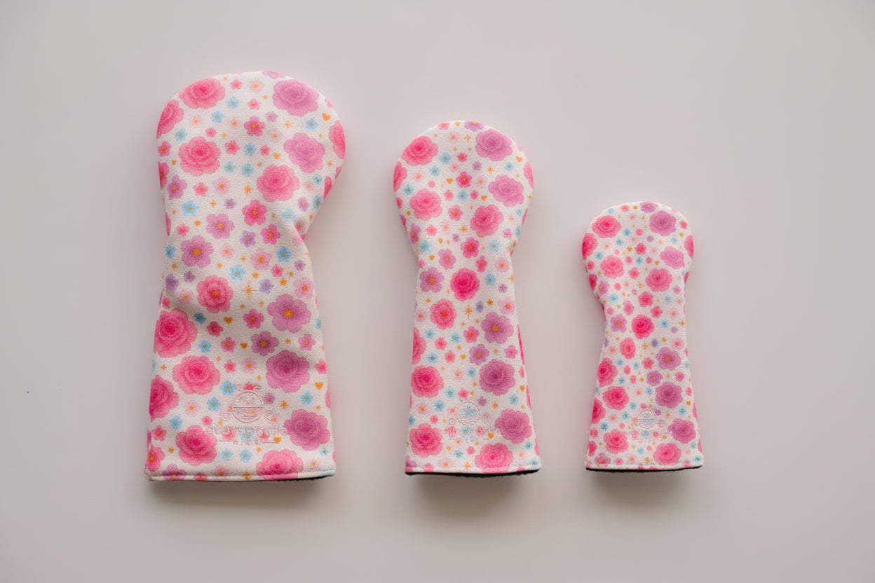 Three floral golf club head covers on a light gray background