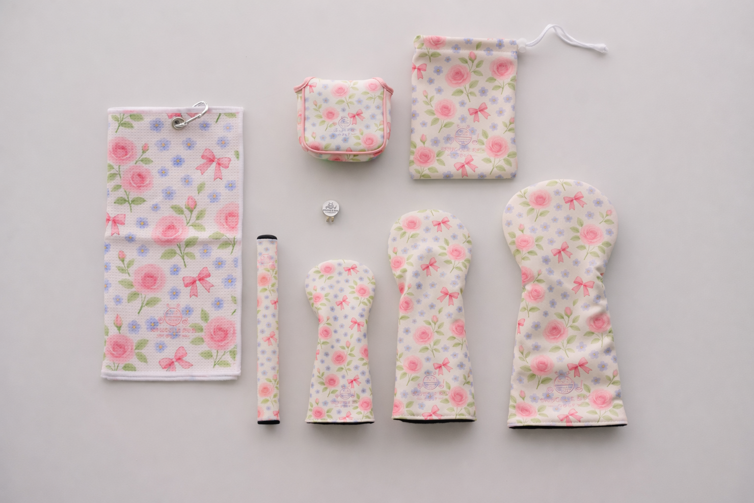 Set of floral-patterned golf club covers and accessories on a gray background