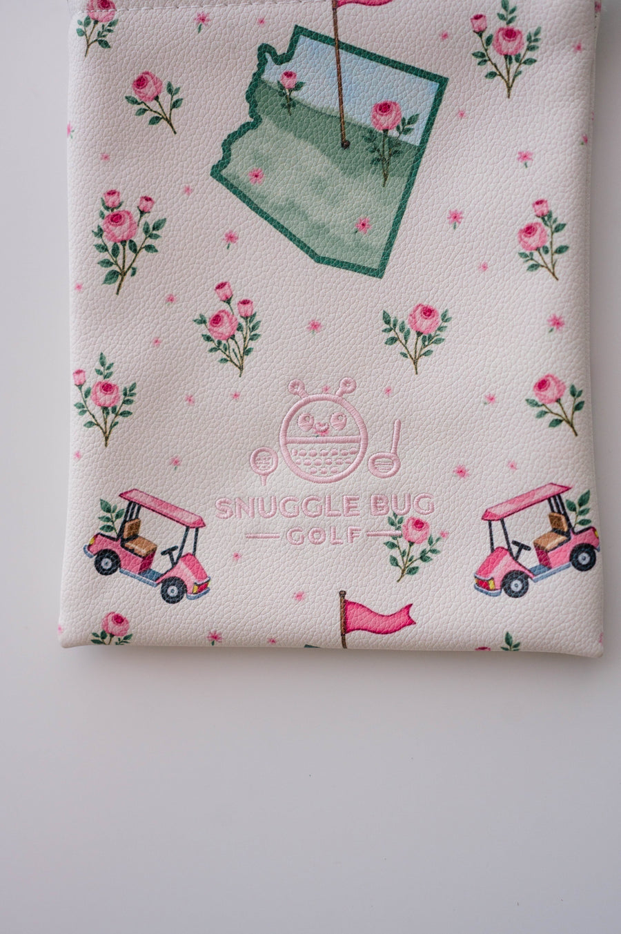 Snuggle Bug Golf Arizona Bloom drawstring pouch in white pebbled eco-leather with pink floral and golf cart print.