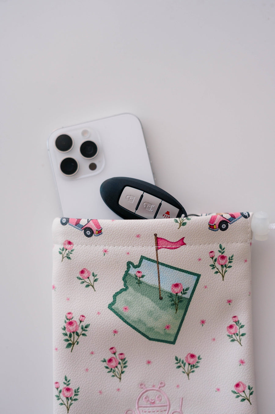 Snuggle Bug Golf Arizona Bloom drawstring pouch in pebbled eco-leather with floral and golf cart print.