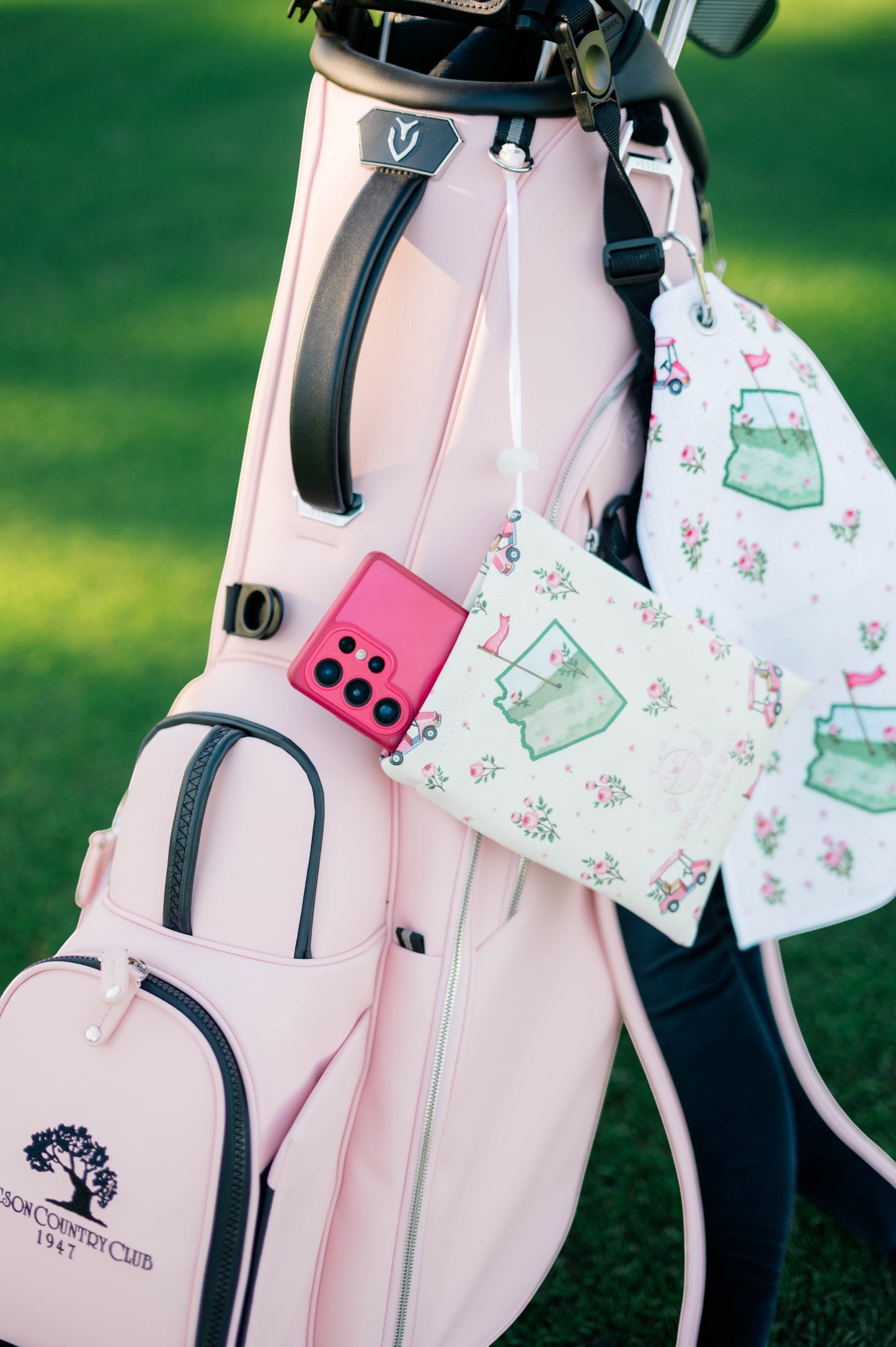 Snuggle Bug Golf Arizona Bloom drawstring pouch with cactus and rose print hanging on a pink golf bag.