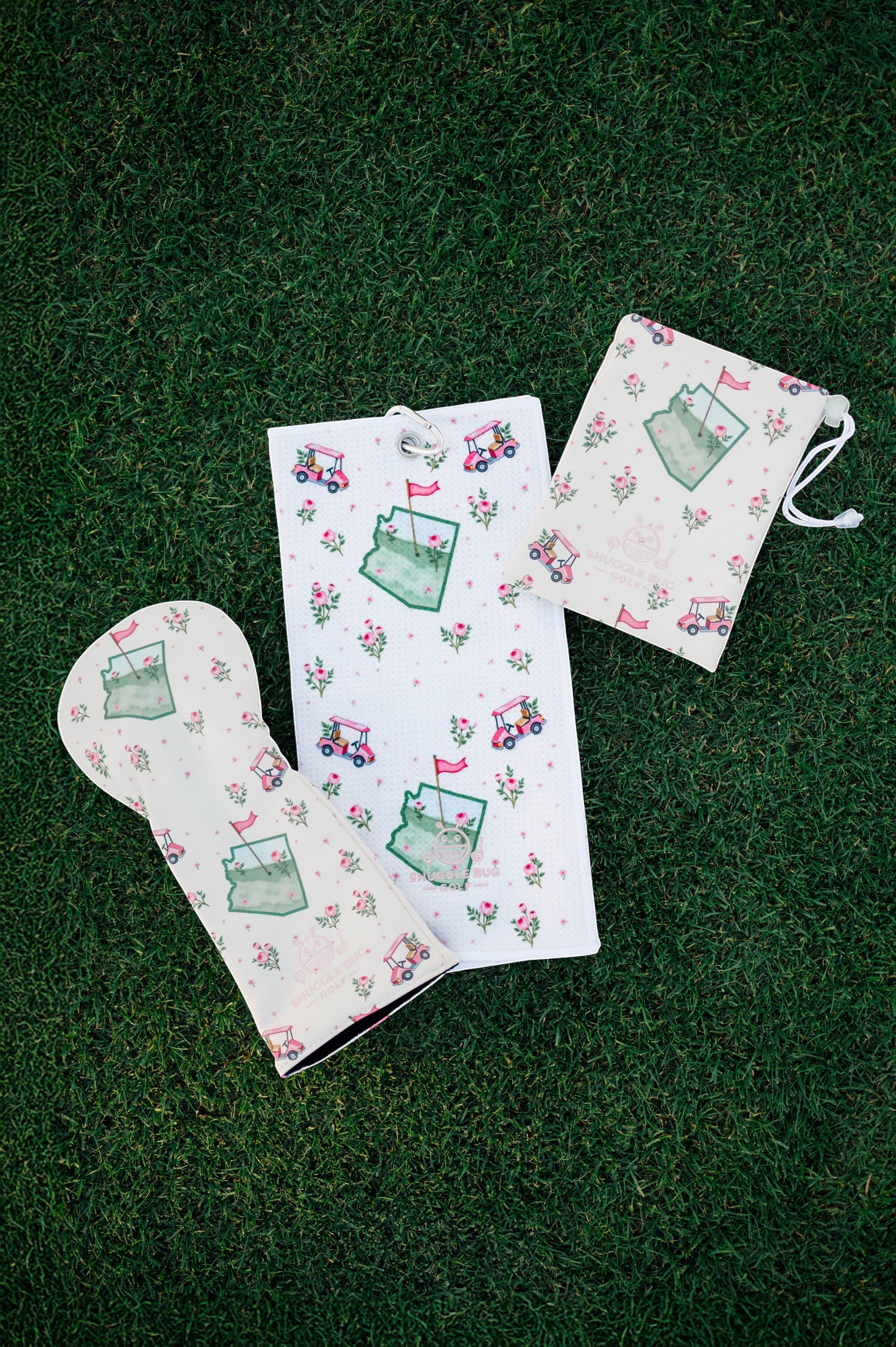 Snuggle Bug Golf Arizona Bloom collection featuring a golf club cover, waffle towel, and drawstring pouch on grass.