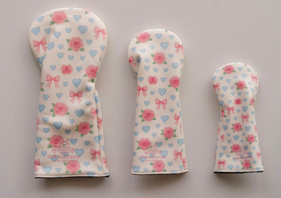 Snuggle Bug Golf 3-piece headcover bundle featuring a white floral rose, heart, and bow pattern for golf clubs.