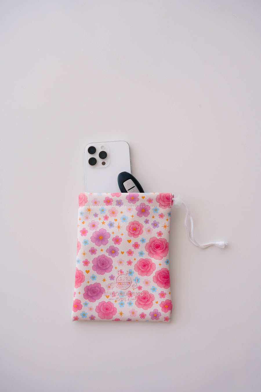 Snuggle Bug Golf Starlight Bloom drawstring pouch featuring pink florals, violet daisies, and stars with a phone.