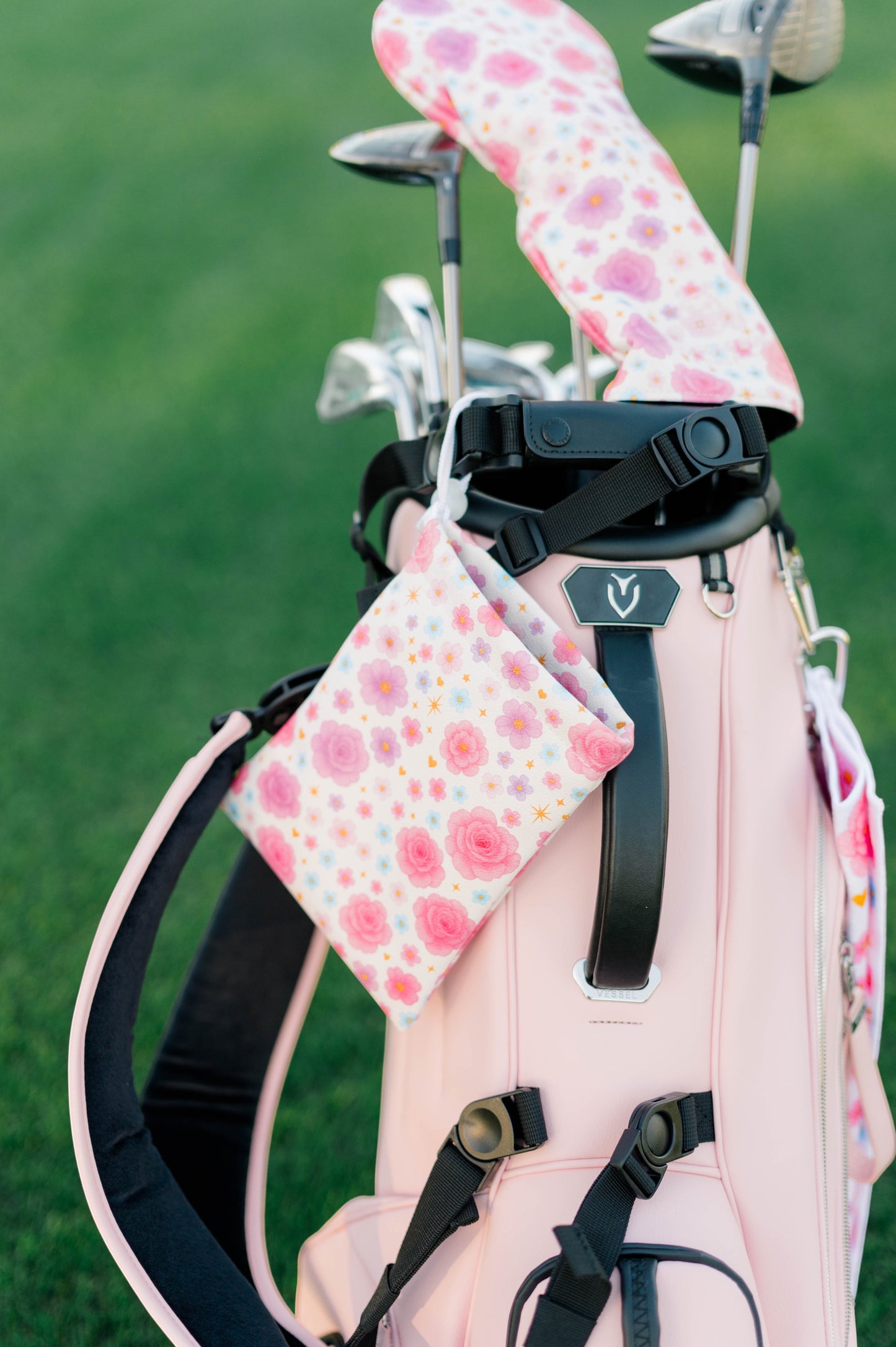 Snuggle Bug Golf Starlight Bloom drawstring pouch with pink floral print hanging on a light pink golf bag.