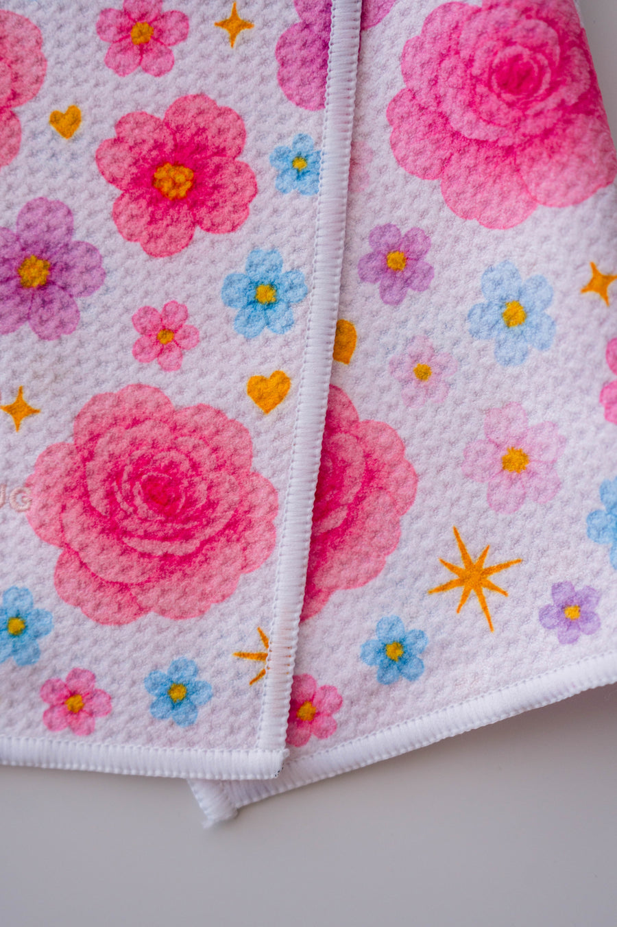 Snuggle Bug Golf Starlight Bloom waffle microfiber towel with pink roses, lavender flowers, and golden stars.