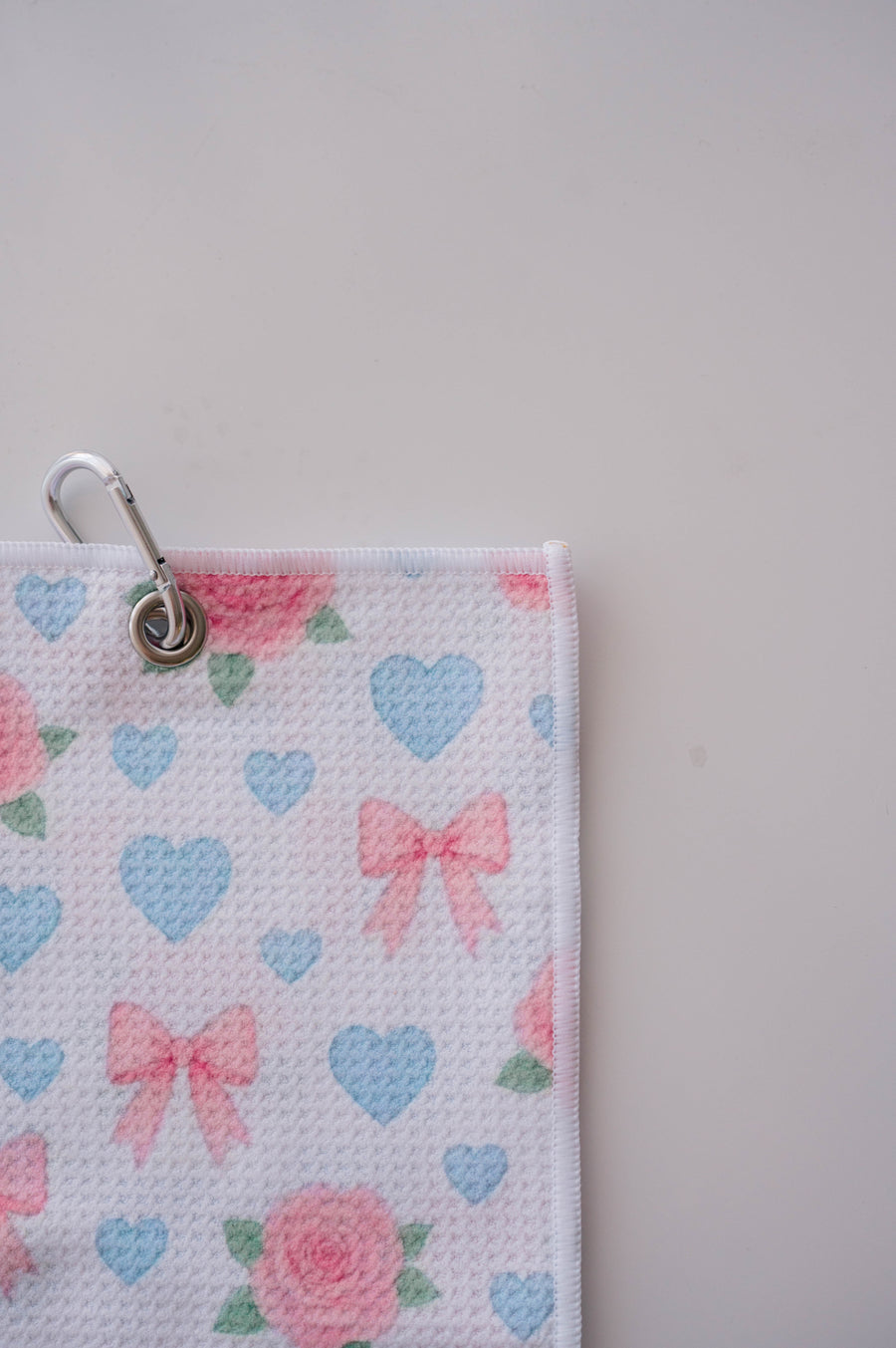 Snuggle Bug Golf waffle microfiber towel with pink roses, blue hearts, and blush bows, featuring a silver hook.