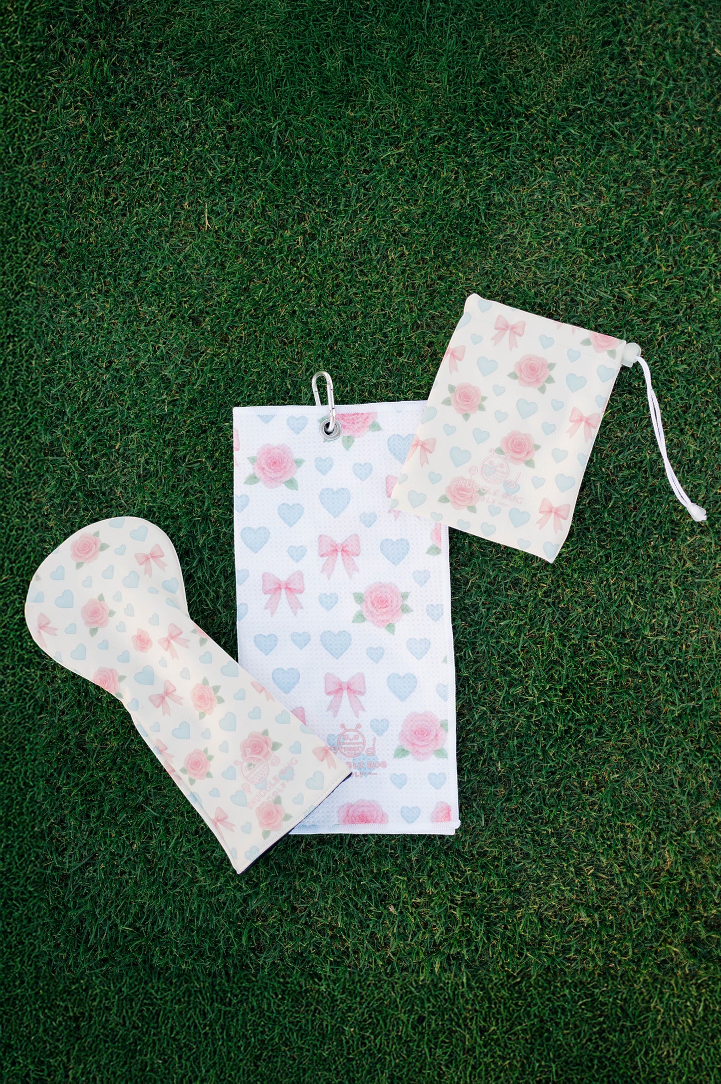 Snuggle Bug Golf Sweetheart Rose waffle microfiber golf towel with pink roses, blue hearts, and bows on green grass