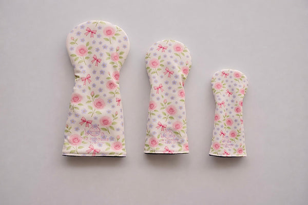 Snuggle Bug Golf Whisper Rose 3-piece golf club headcover set featuring floral and bow print on a light background.