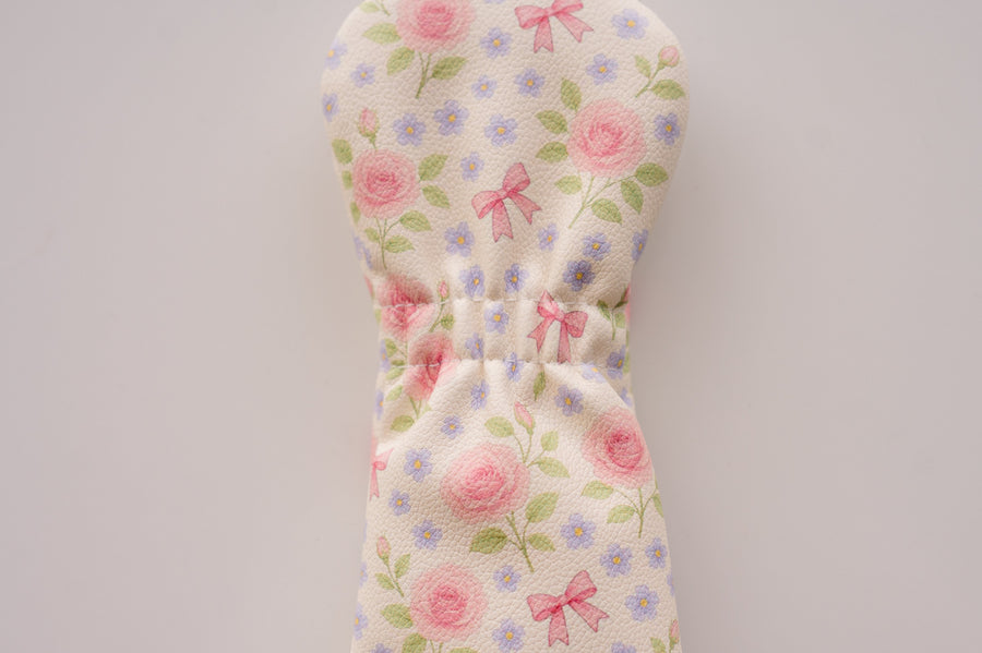 Snuggle Bug Golf Whisper Rose hybrid headcover with blush floral print, pink bows, and textured eco-leather finish.