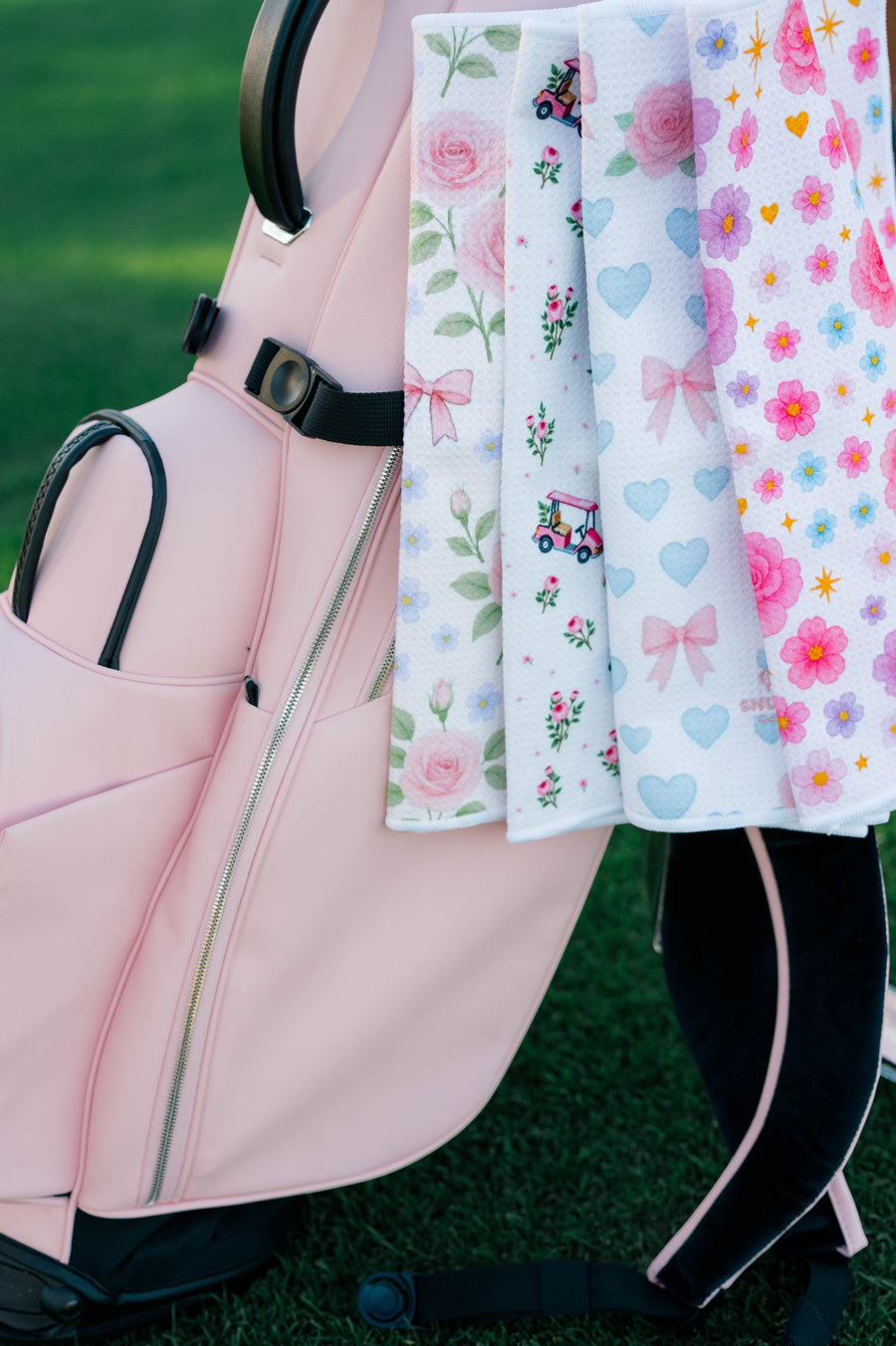 Snuggle Bug Golf Whisper Rose microfiber waffle towel with floral print hanging from a light pink golf bag