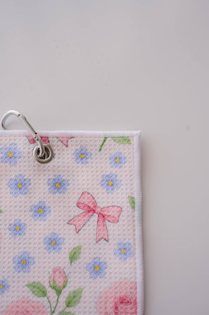 Snuggle Bug Golf Whisper Rose microfiber golf towel with floral print, pink bows, silver grommet, and hook.